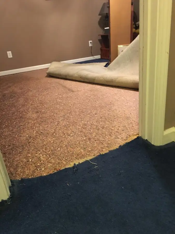 Carpet pad removal revealing water damage during Water Mitigation Services in Mooresville